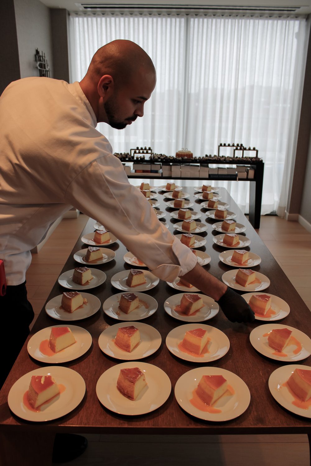 Chef Kaynan plating Brazilian flan for dessert service at a private event