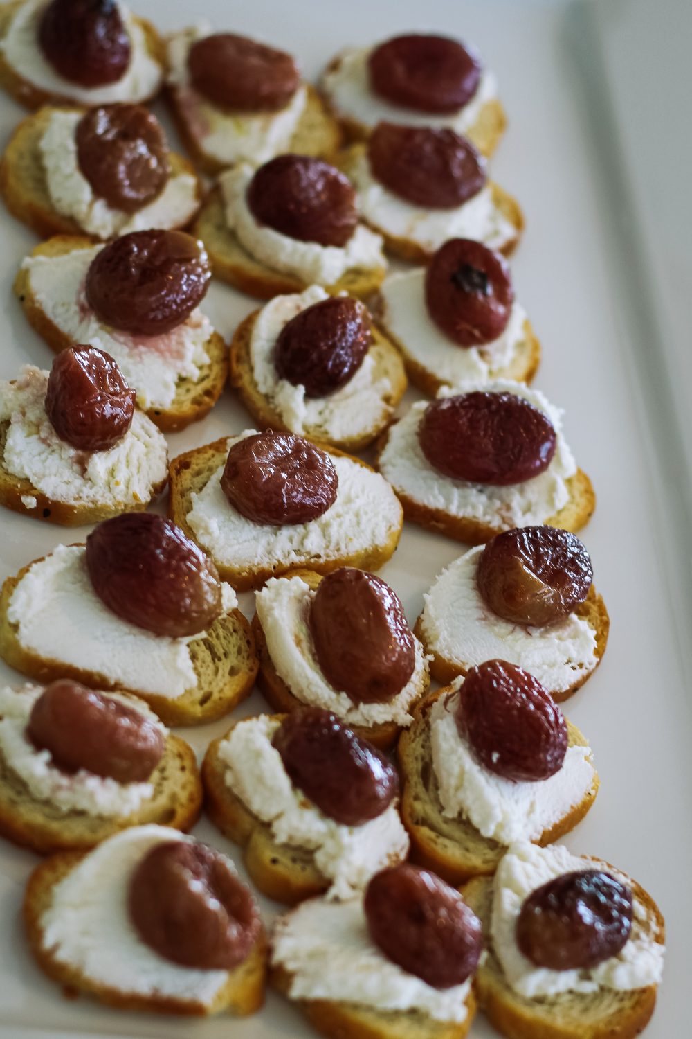 Crostini with whipped ricotta and roasted grapes, a passed bite