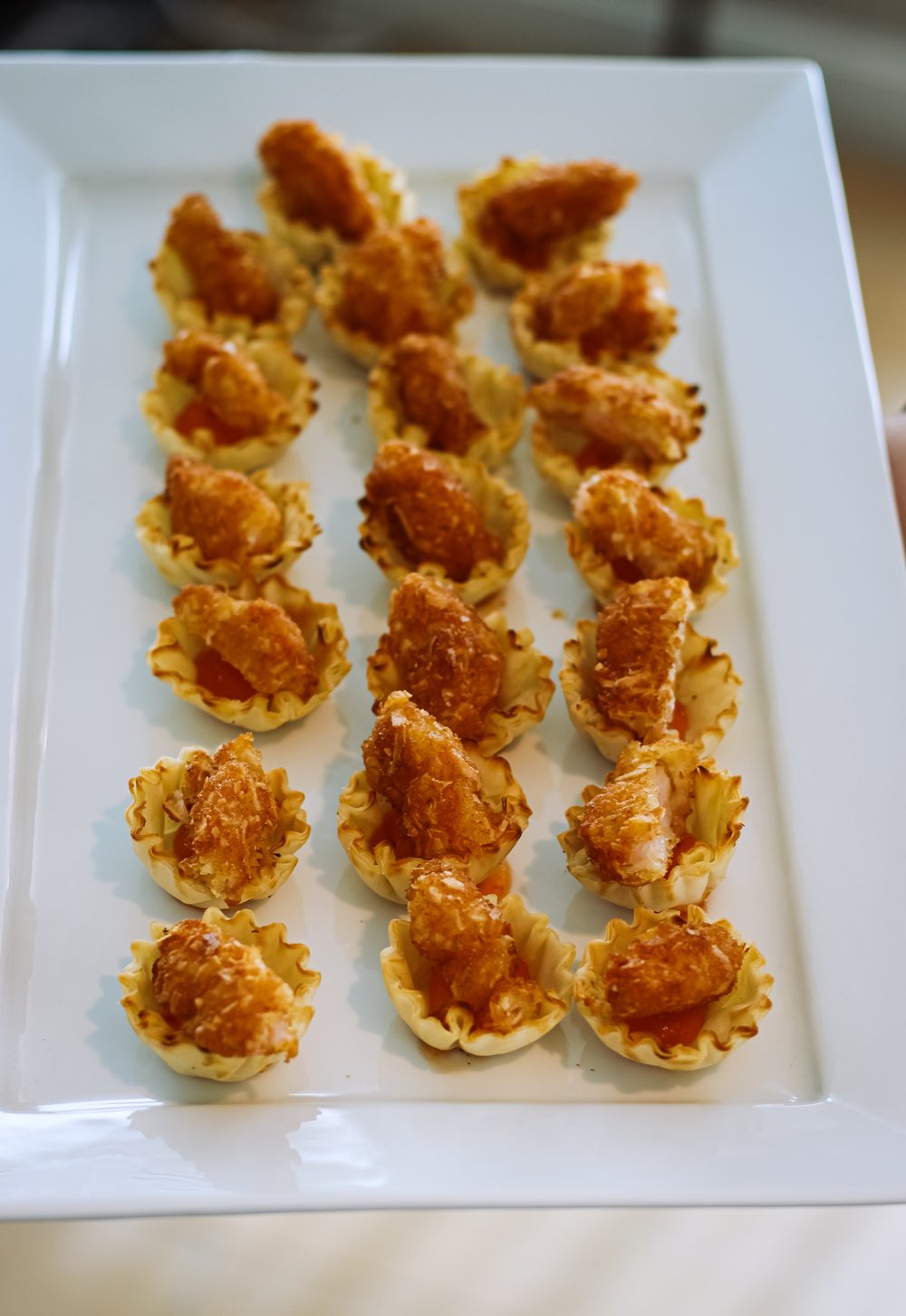 Phyllo cup canapes lined up on a white platter for a private event