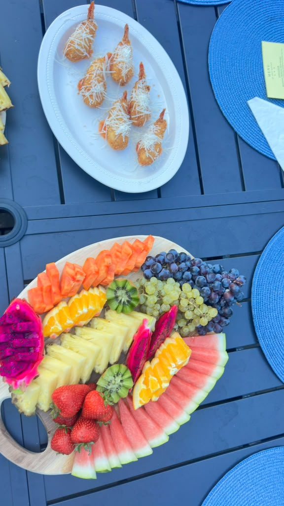 Parmesan shrimp bites plated alongside a tropical fruit board