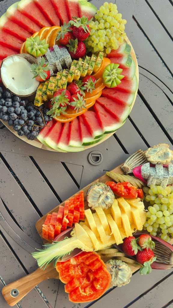 Two tropical fruit boards on an outdoor table