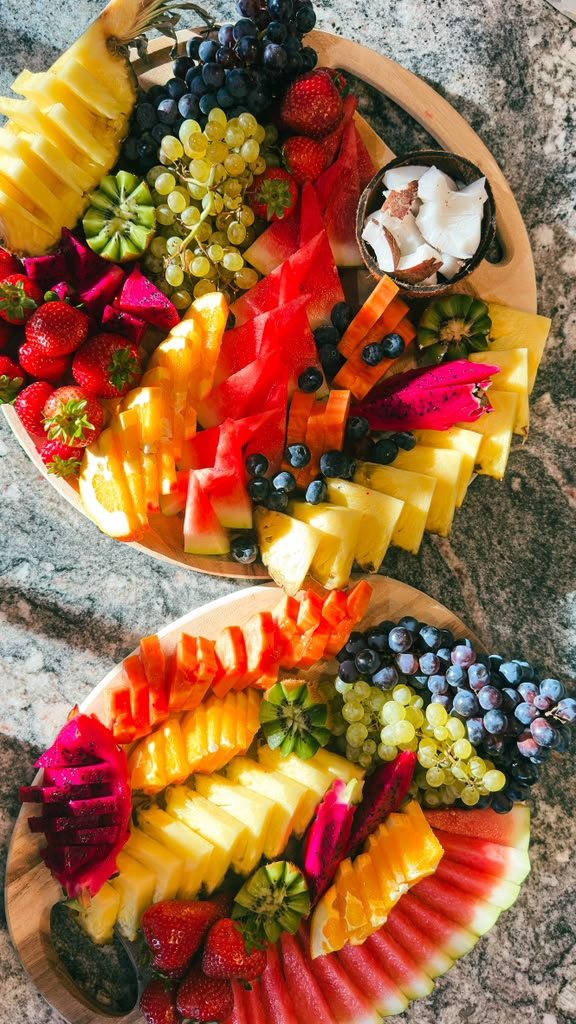 Two tropical fruit boards on a marble counter