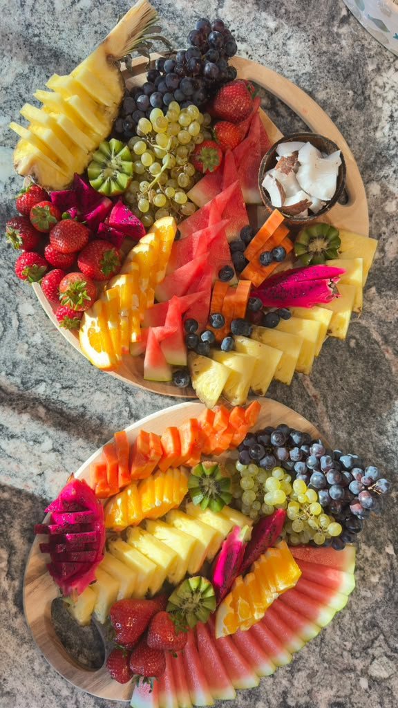 Two tropical fruit boards on a granite counter